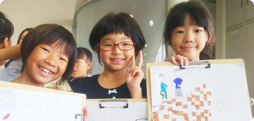 作品を見せながら笑顔を見せる子どもたち